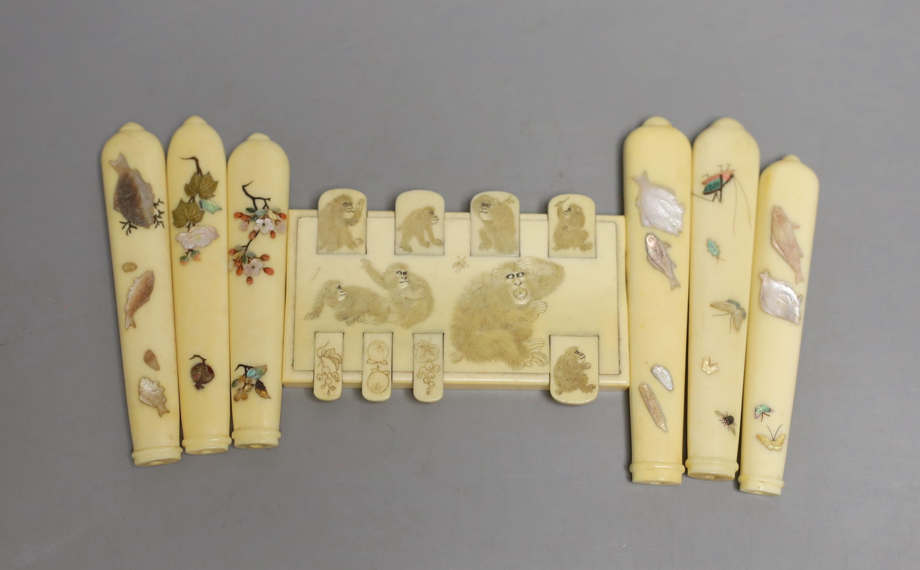 A carved ivory Japanese bezique marker and six Shibayama style ivory handles, Meiji period marker 9cms wide x 6 high.